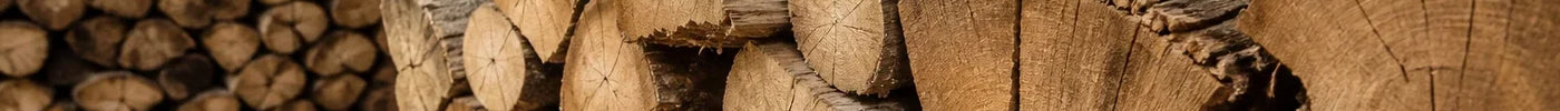 Strak gestapelde pallet ovengedroogd haardhout onder afdak, met een vochtmeter op een blok